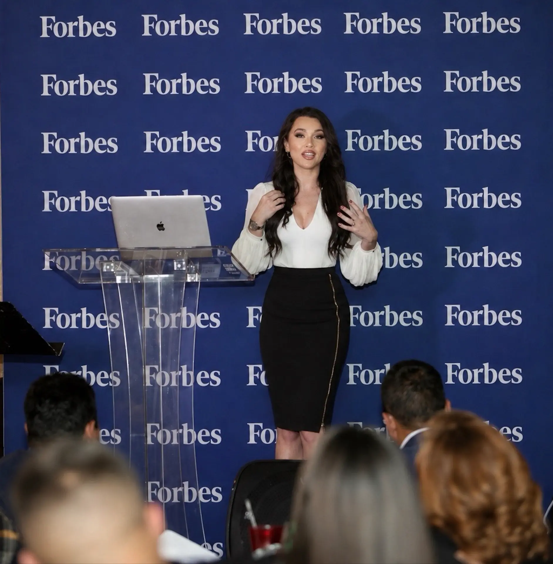 Emanuela Pop speaking on stage at a Forbes event